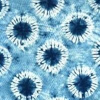 Blue indigo shibori tie-dye fabric pattern with white circular bursts