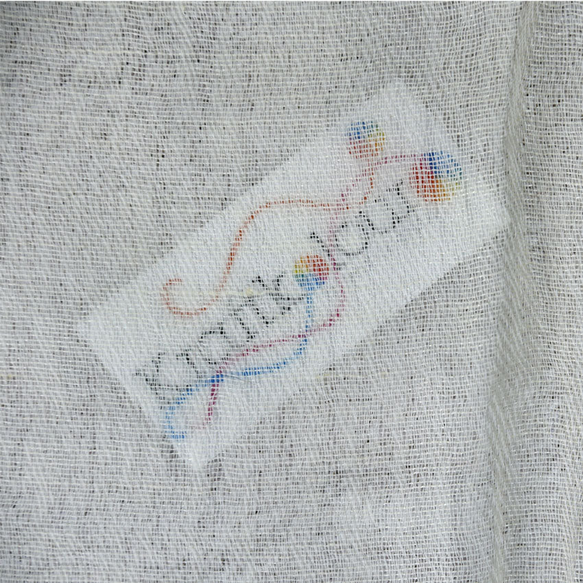 Close-up of grey wool-silk fabric weave with Kraft Kolour label tag