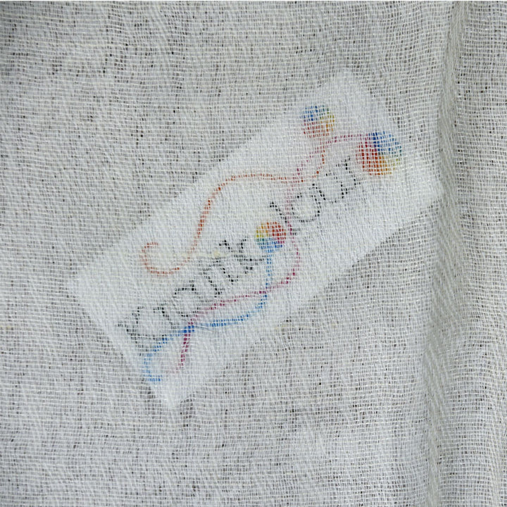 Close-up of grey wool-silk fabric weave with Kraft Kolour label tag