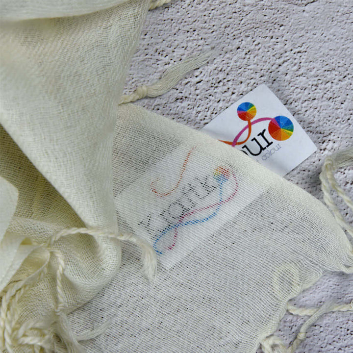 Merino wool twill shawl tassel detail with colourful tag on cream fabric